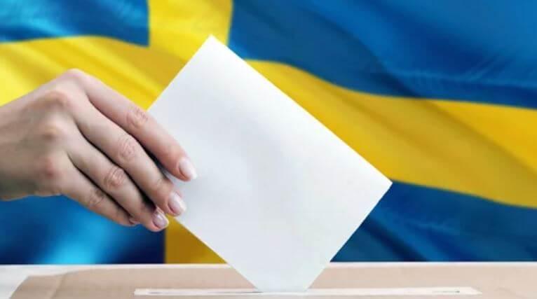 Gul och bla svenska flaggan, hand med kuvert som rostar - val 2022 Sverige odds