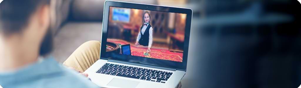 Man med laptop spelar online - Live Casino Roulette -live dealer - recension